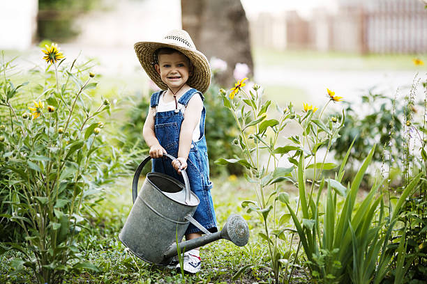 istock little boy with watering can in summer park 483635060