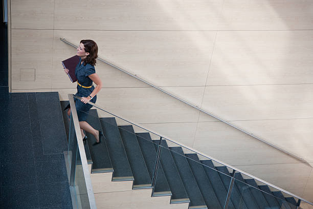 geschäftsfrau aufsteigender büro-treppe - staircase walking office steps stock-fotos und bilder