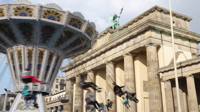 Carousel spinning. Brandenburg gate on background