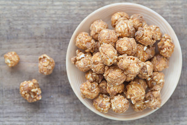 istock Almond and caramel popcorn on wood background 483655178