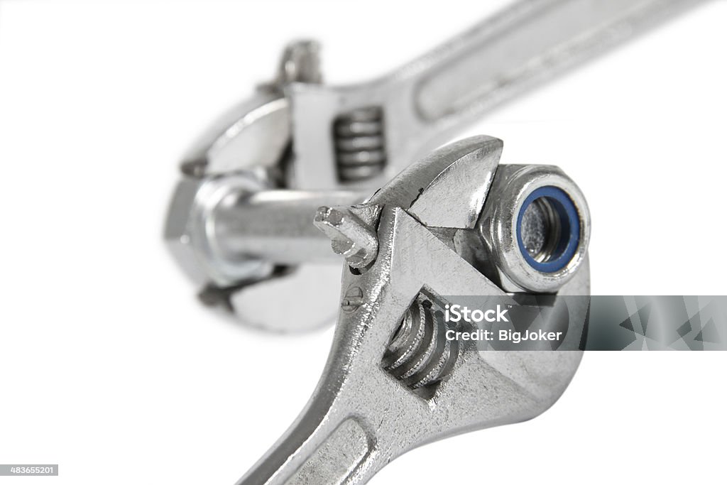 Wrench with a nut Wrench which is turning off a nut from a bolt, on a white background Adjustable Wrench Stock Photo