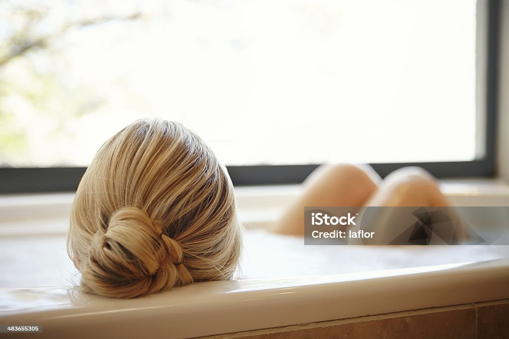 Vue arrière de femme blonde dans la salle de bains - Photo de Baignoire libre de droits