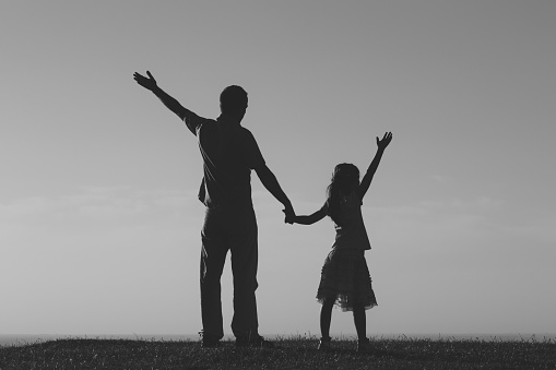Father and daughter enjoy outdoor together.Photo is intentionally black and white.