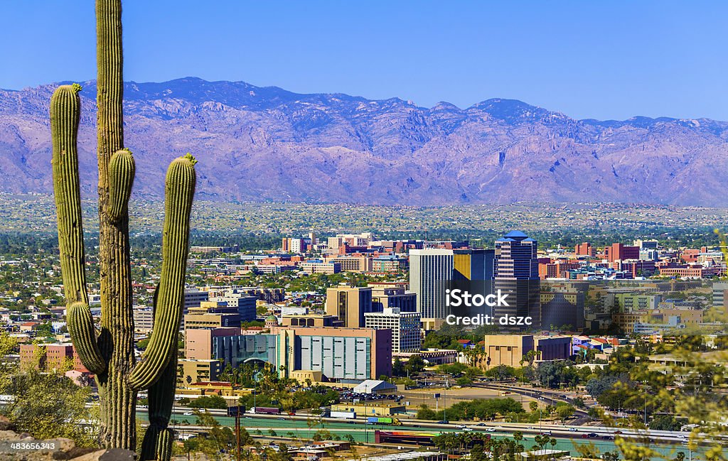 Tucson Arizona skyline cityscape framed by saguaro cactus and mountains Tucson Stock Photo