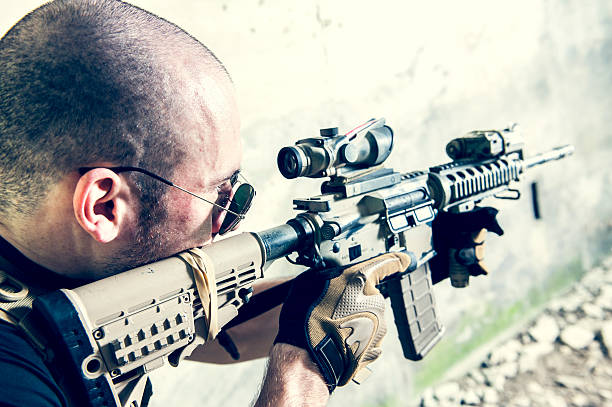 Contractor Soldier Aiming an Assault Rifle with Shaved Head stock photo