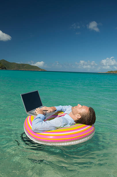 istock Floating Businessman Does Extreme Daydreaming with Laptop in Sea 483659443
