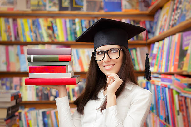 istock Happy Student with Graduation Cap Holding Books 483659630