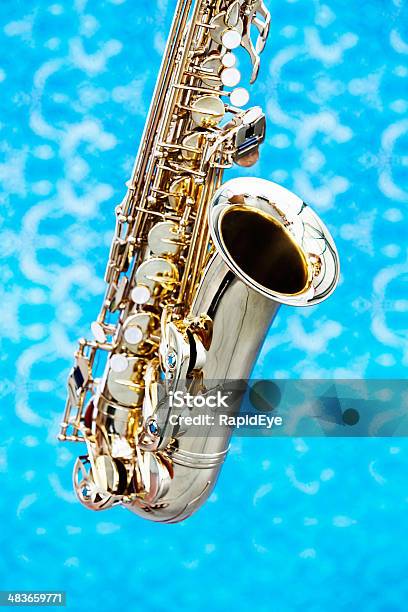 Cropped Look At Bell And Keys Of Saxophone Against Blue Stock Photo - Download Image Now