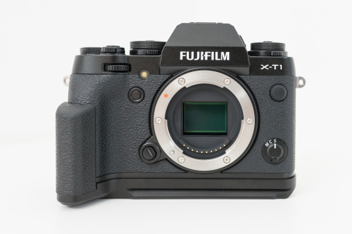 Stuttgart, Germany - April 8, 2014: Fuji X-T1 Fujifilm Mirrorless Camera Body front view without lens and attached Fuji MHG-XT Metal Hand Grip isolated on white background.