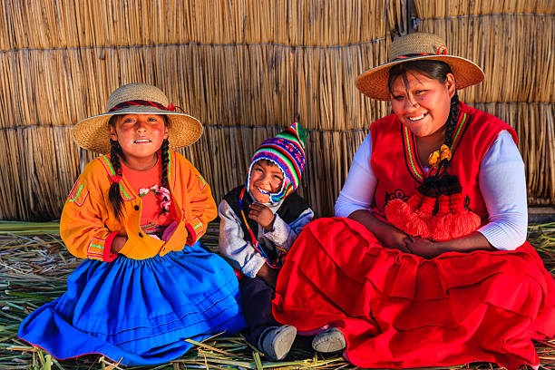 madre y niños jugando en islas flotantes de uros, el lago tititcaca, perú - trajes tipicos del peru fotografías e imágenes de stock