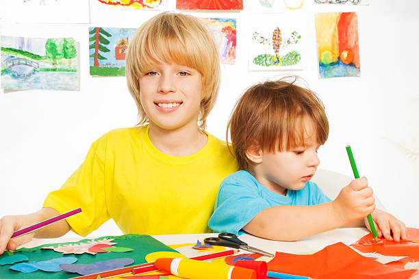istock Little happy boys play with paper 483661105