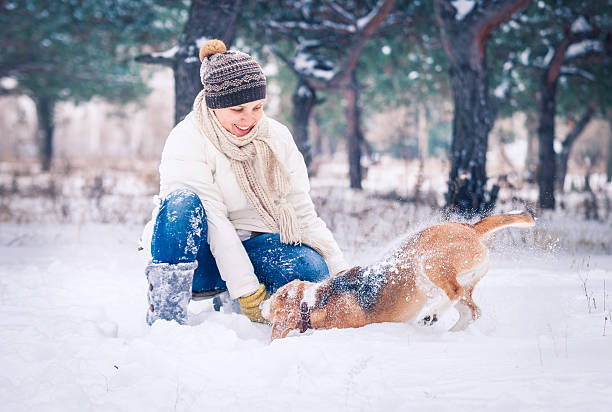 istock Happy Woman Playing With Her Pet In Snow 483662655