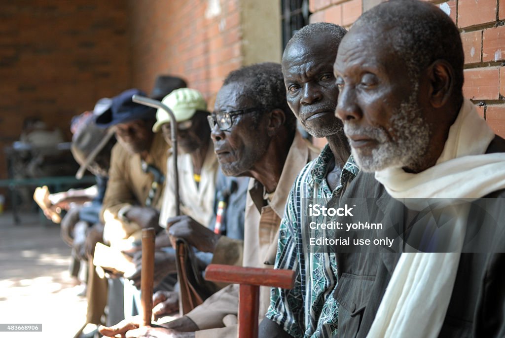Veterans of Africa Moundou, Chad - October 30, 2012: We can see a group of old African men sitting in them village, thinking of the past. They are old soldier who fight for France in 1959.  Africa Stock Photo