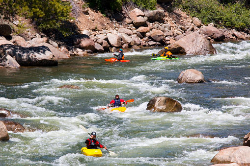 Buena Vista, Colorado, USA - July 11, 2015: People enjoying whitewater sports, including whitewater rafting and kayaking on the roiling whitewater of the Arkansas River near Highway 24 in Buena Vista Colorado