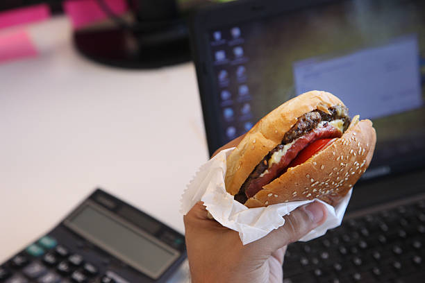 istock businessman being deep in work having a hamburger at lunch 483670569