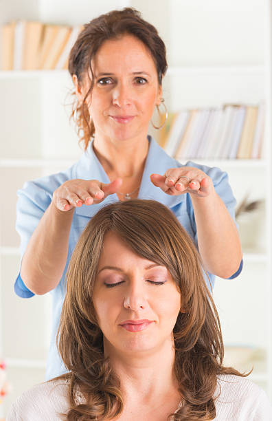 reiki de guérison - reiki alternative therapy massaging women photos et images de collection