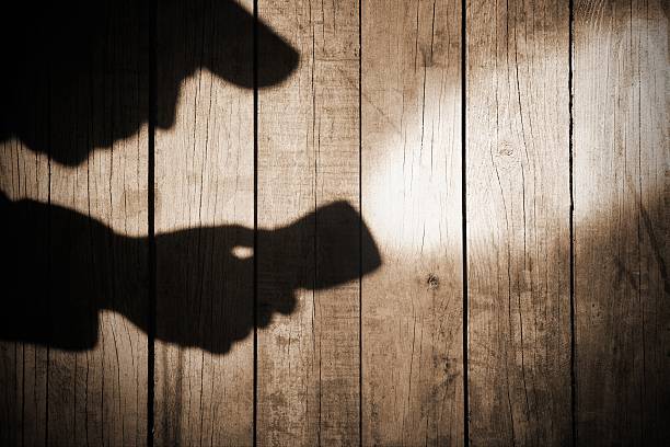 istock Detective Silhouette with a serchlight on Grungy Wooden Backgrou 483671499