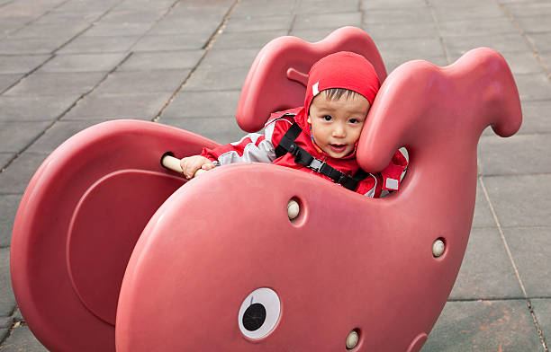 istock baby boy playing on a  playground equipment 483671671
