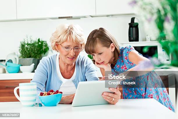 Grandma Using Digital Tablet With Grandchild Stock Photo - Download Image Now - Child, Digital Tablet, Kitchen