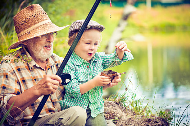 la pêche - fishing lake grandfather grandson photos et images de collection