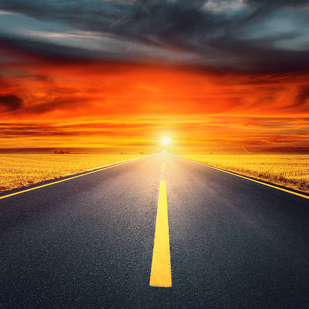 istock Driving on an empty asphalt road towards the setting sun 483677347