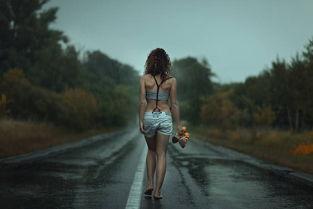istock Girl back. Walks on the road. Under rain. 483677810
