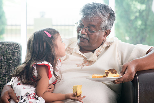 Granddaughter y abuelo comiendo torta photo