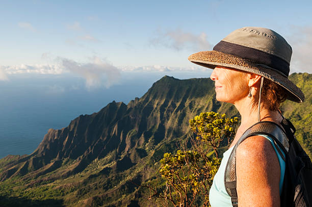 mulher madura na bela paisagem em observação de kalalau, kauai - kauai tropical climate green travel destinations imagens e fotografias de stock