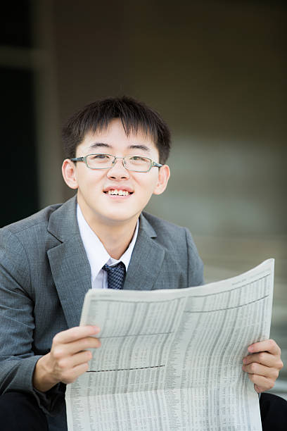 istock Young businessman reading newspaper 483687019