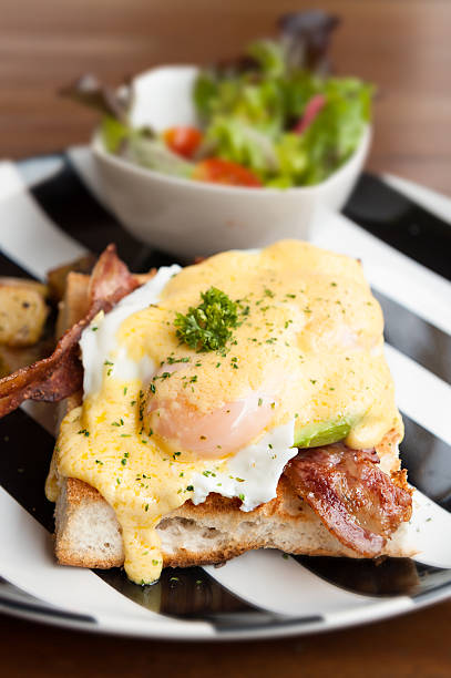 istock eggs benedict  breakfast bacon poached egg, potaots and salad 483687360