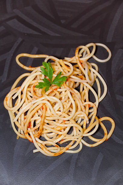 freschi cucinati spaghetti con prezzemolo sul piatto verde - teigwaren foto e immagini stock