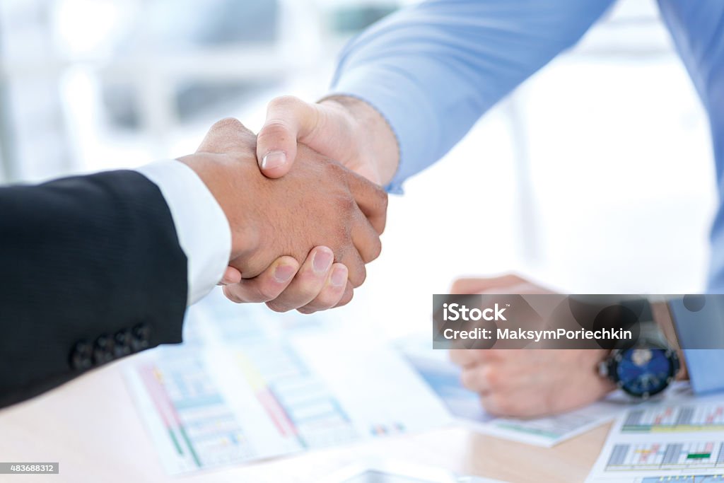 Men shaking hands. Confident businessman shaking hands with each Men shaking hands. Confident businessman shaking hands with each other. Close-up view of the hands of a businessman in the office of the table in the formal wear. 2015 Stock Photo