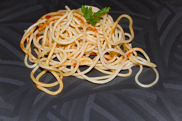 freschi cucinati spaghetti con prezzemolo sul piatto verde - teigwaren foto e immagini stock