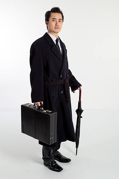 istock Chinese business man standing with umbrella and suitcase 483688505