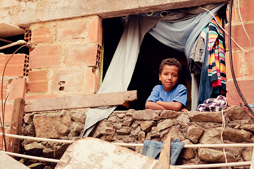 A young Brazilian boy looks out his bedroom window in the Santa Marta favela of Rio de Janeiro.