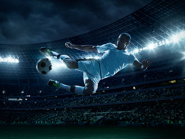 football joueur shootant dans un ballon - soccer player men flying kicking photos et images de collection