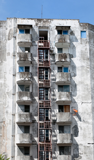 run down concrete and rusty apartment building with balconies