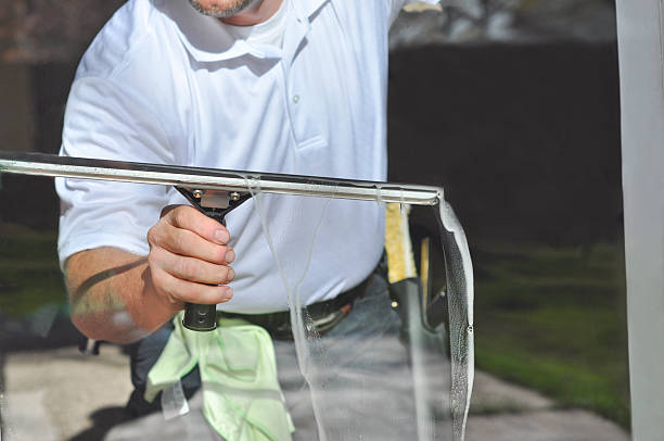 Clear Window A window cleaning professional uses a large squeegee to clean the water and soap suds off of a residential window. washing windows stock pictures, royalty-free photos & images