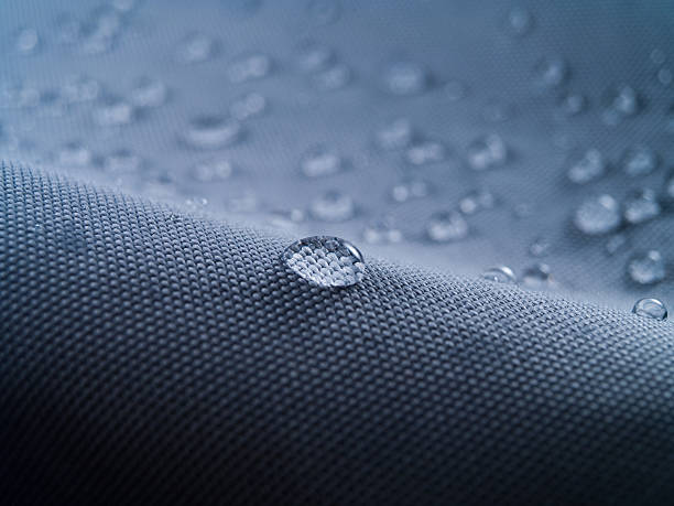 waterproof textile clothing blue Macro shot of water rain drops on waterproof textile jacket. Extreme depth of field. Please visit my portfolio for different shots of this subject. water repellent stock pictures, royalty-free photos & images