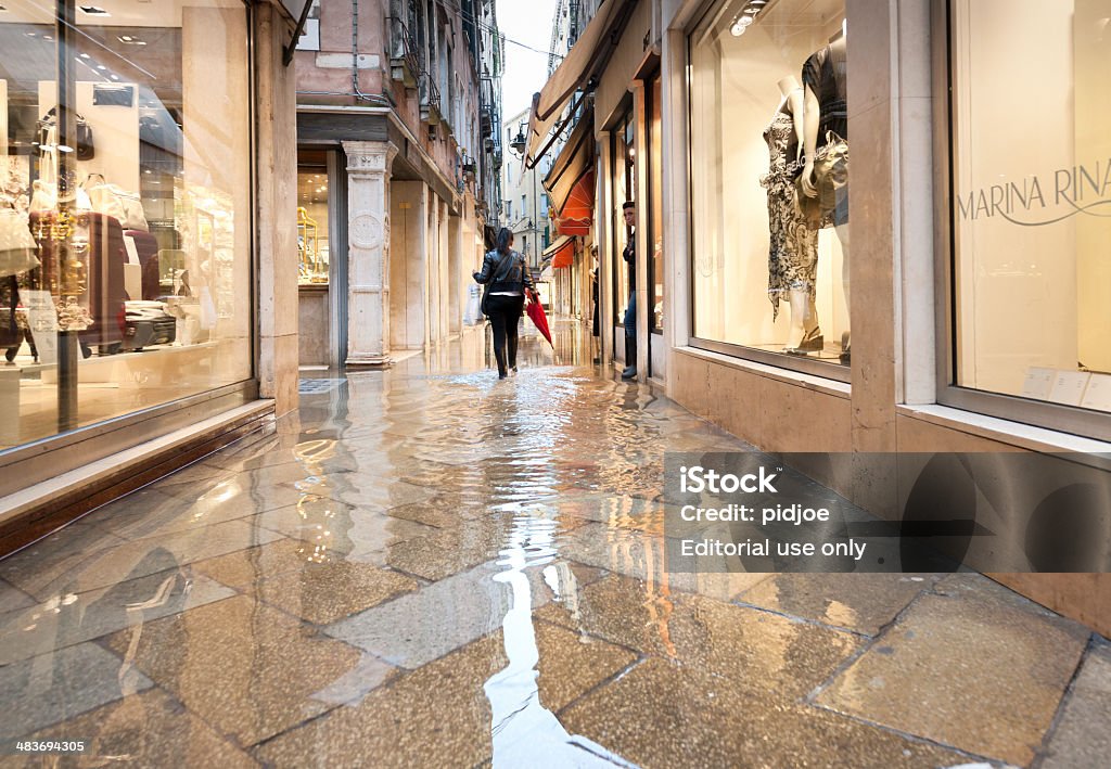 Mulher com botas percorrer inundada Beco em Veneza Itália - Royalty-free Enchente Foto de stock