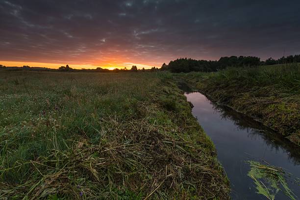 istock Beautiful sunrise over misty meadow and stream 483695066