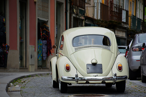Porto, Portugal - May 02 , 2015: Old fashioned car going on Porto's old town street. The Volkswagen Type 1, widely known as the Volkswagen Beetle, was an economy car produced by the German auto maker Volkswagen (VW) from 1938 until 2003.