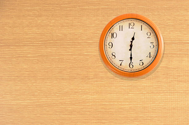 istock Clock showing 12:30 o'clock on a wooden wall 483702298