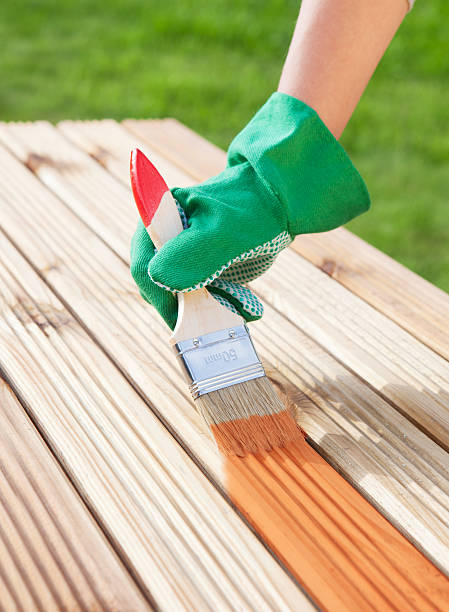 istock Applying protective varnish on a patio wooden floor 483702682