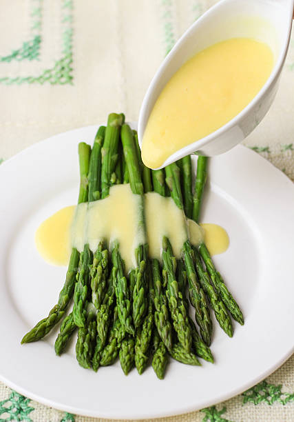 freshly cooked green asparagus with hollandaise sauce freshly cooked green asparagus with hollandaise sauce. Selective focus hollandaise sauce stock pictures, royalty-free photos & images