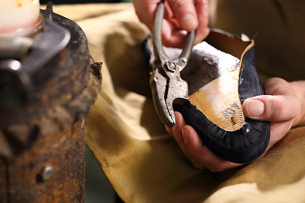 istock Shoemaker shears the edges of the skin 483711928