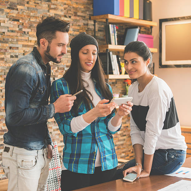 istock People with mobile phones in the office 483713164