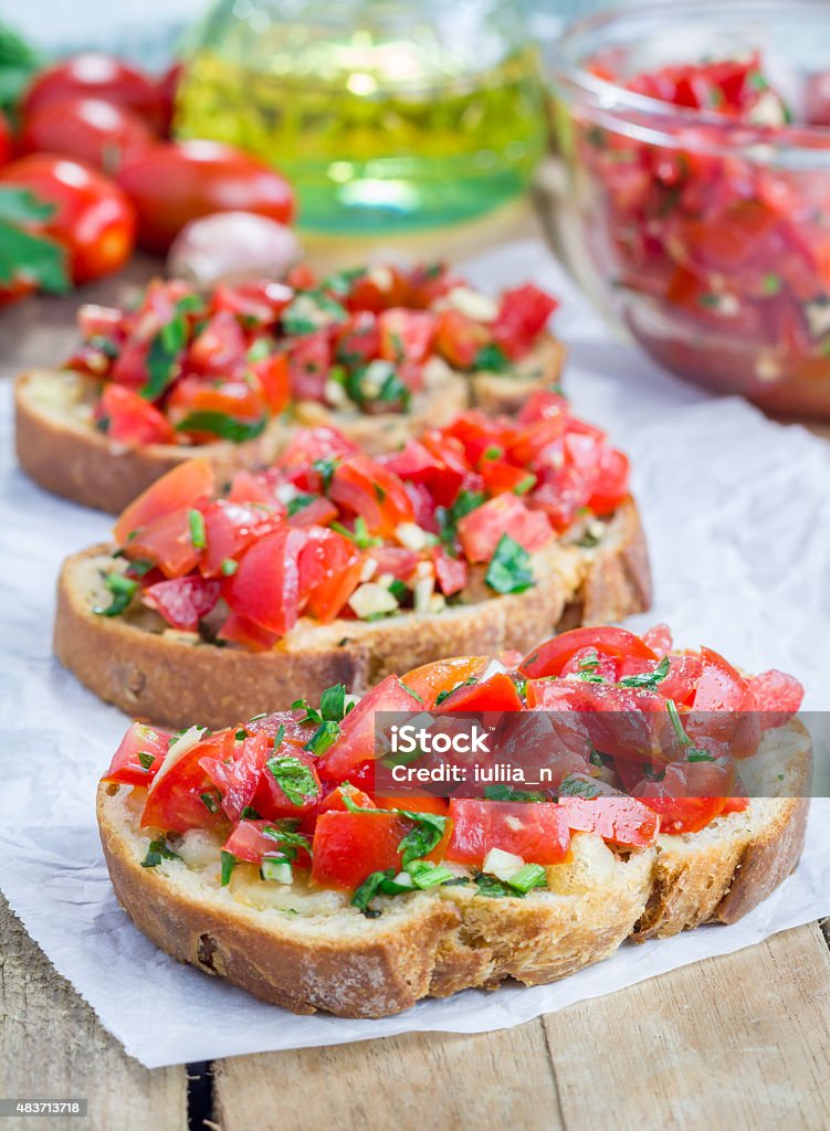 Bruschetta with tomatoes, herbs and oil on garlic cheese bread Bruschetta with tomatoes, herbs and oil on toasted garlic cheese bread 2015 Stock Photo