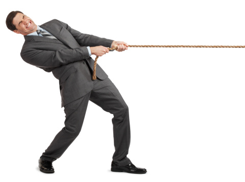 Businessman Pulling On Rope On White Background Stock Photo