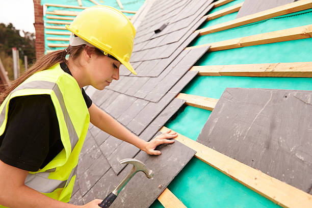 istock Female Construction Worker On Site Laying Slate Tiles 483717684